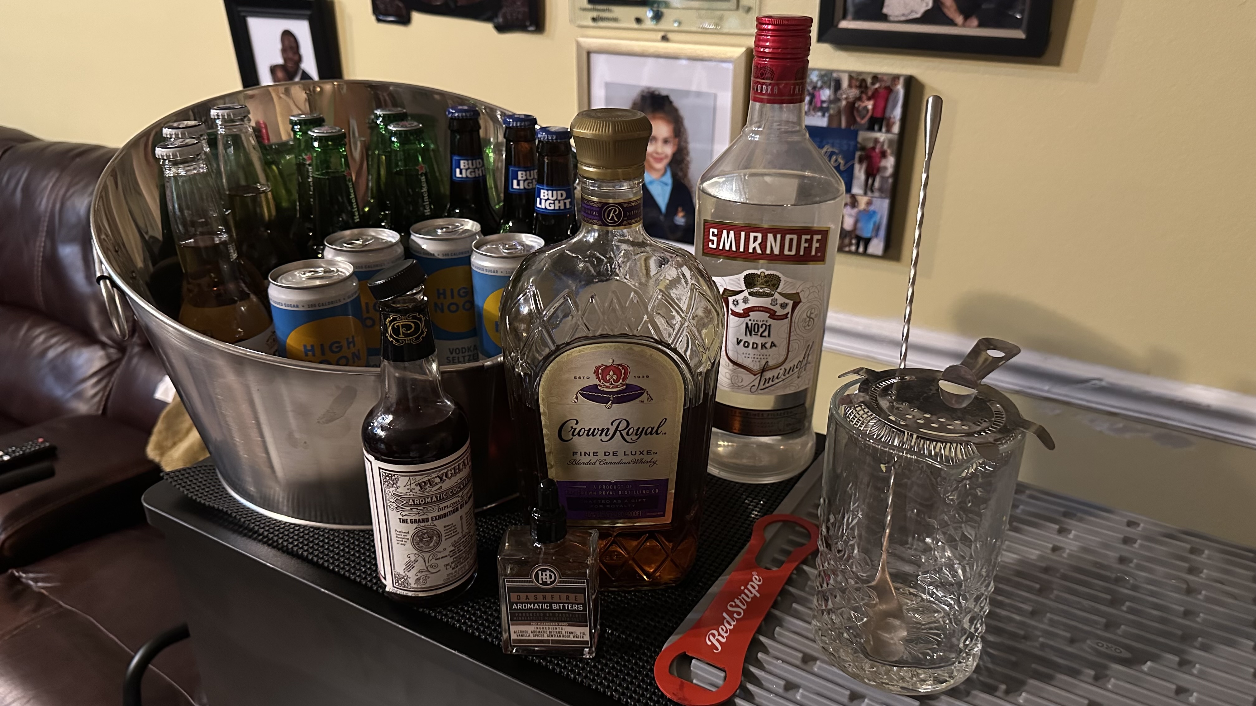 A stocked mobile bar cart with beer, spirits, and bar tools